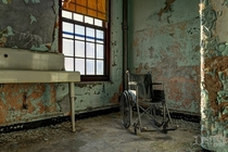 A Lone Wheelchair Sitting in the Waning Sunlight at an s Asylum OC x