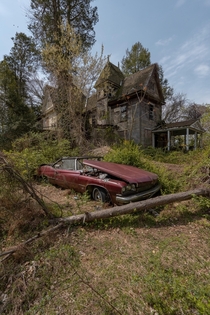 A nice classic car with an even nicer abandoned house in the back