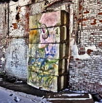 A painted-over face inside an empty warehouse 