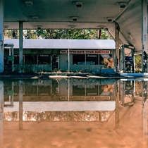 A reflection of an abandoned gas station