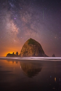 A single image of Cannon Beach with the Milky Way and a meteor above 