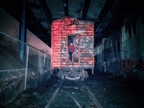 A very old photo of an abandoned boxcar under a highway in the Bronx
