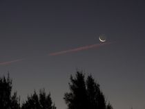 A waxing crescent Moon and a contrail after sunset