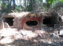 Abandoned cemetery in Florida with broken open vaults A casket is visible in the far right vault only a few bones are present and one of the casket lids has been ripped off 