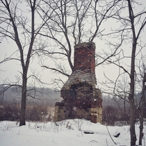 Abandoned chimney during a snow storm