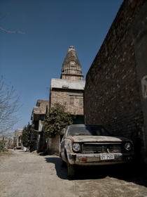 Abandoned old car infront of a temple in Pakistan
