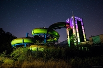 Abandoned Waterpark Slide at night enlighten with colorful speedlights 