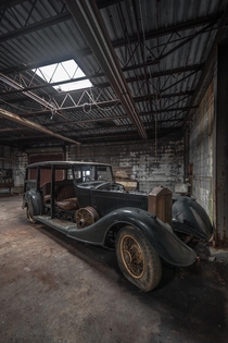 An abandoned Rolls Royce decaying in a factory
