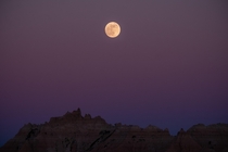 An almost full moon rising over the Badlands Badlands National Park South Dakota 