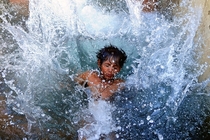 An Indian kid cools off in a watering hole on a hot day in Allahabad 
