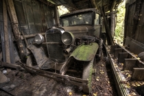 An old Ford model A Slowing rusting away in a garage 