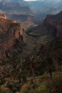 Bright Angel Trail at the Grand Canyon Arizona This was taken about a mile down into while the sun was just below the East canyon wall If you look closely you can see the trail winding down through the valley in the center 