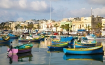 Colorful luzzu boats in Marsaxlokk harbor Malta 