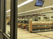 Completely empty plaza grocery store with CCTV and registers still running