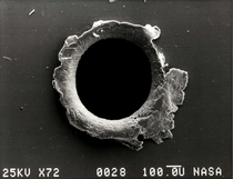 Debris hole in a panel of the SMM Satellite View of an orbital debris hole made in the panel of the Solar Max satellite Credit NASA