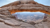 Enjoying the sun reflecting off the red rock wall of the Mesa Arch  Canyonlands National Park Moab UT 