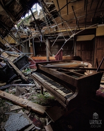 Grand piano left in a dilapidated hotel England 