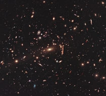 Hubble image of galaxy cluster MACS J with visible gravitational lensing 
