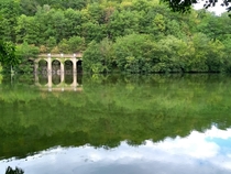 I came across this peaceful body of water with an abandoned railway bridge