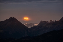 I walked up a mountain in the Swiss Alps to capture the moonset - unfortunately it was really cloudy but I got a quick peak at the moon just after it was above the mountains Mount Jnzi Switzerland 