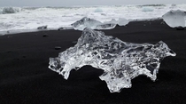 Ice crystal lying in black lava sand Diamond beach Iceland 