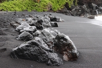 Lava rocks on a black sand beach in Maui Hi 