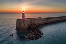 Light Beacon - sun setting behind the lighthouse at Newhaven 