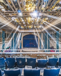 Light rays shine in abandoned school auditorium 