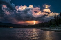 Lightning Strike and a Full Moon over Bass Lake - California  photo by Darvin Atkeson