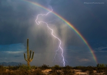 Lightning strikes in front of a rainbow in a southern Arizona desert 