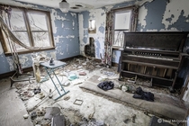 Living room in an abandoned house complete with an organ and ironing board