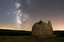 Milky Way shot over la choza a th century shelter used by ranchers to shelter at night and during storms Mud Palencia Spain