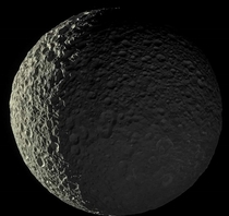 Mimas one of Saturns moons is bathed in sunlight on one side and Saturns reflected sunlight on the other side