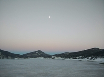 Moon rising over the Icy lake of Campotosto LAquila - Italy during the sunset 