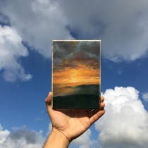 My oil painting of an orange lit sky with some cotton clouds as the backdrop