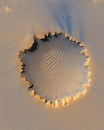 NASAs Mars Reconnaissance Orbiter shows Victoria crater an impact crater at Meridiani Planum near the equator of Mars The crater is approximately  meters half a mile in diameter and it was visited by Opportunity color enhanced
