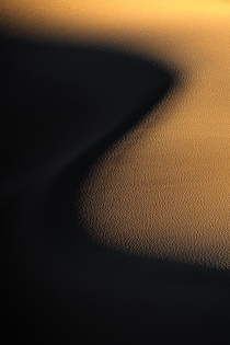 Natural curves of the sand dunes in Death Valley National Park contrast with the last light of the day 