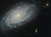 NGC  A Sharper View -- The big beautiful face-on spiral does steal the show but the sharp image also reveals an impressive array of background galaxies 