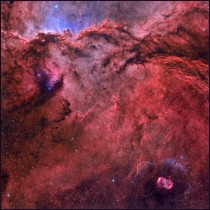 NGC  and NGC   is forming massive young stars One of these O-type stars formed  lower right which is a rare emission nebula with a striking symmetric gaseous shroud and faint halo surround its bright central star 