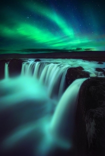 Northern Lights over Godafoss Waterfall in Iceland  IG joseramosphotography