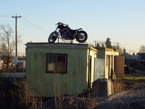 Old abandoned motorcycle on a building Strange