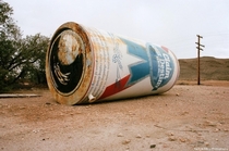Old water tank in the Mojave Desert The Claim Your Destiny Beer painting is some kind of art installation The writing on the bottom is a bunch of negative statements about society and alcohol consumption