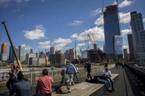 Pedestrians walk along New Yorks High Line with  Hudson Yards standing in the distance Photographed by John Taggart for Bloomberg 
