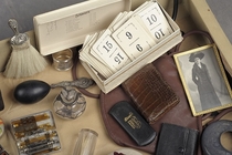 Pics of a trunk left in a NY insane asylum of patient Flora T Who was locked away for the rest of her life In her possessions a perfume bottle and silver napkin ring reveal a woman of class However the kit of needles and injection drugs add a dark element
