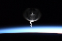 Picture taken from ISS of a rocket bringing astronauts to ISS  The rocket is in the second stage of its journey towards ISS 