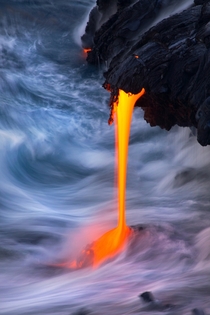 Raging Battle - molten lava dripping into the ocean near Kalapana Hawaii  by Bruce Omori