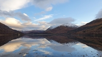 Reflection of snow capped hills around Loch Creran Scotland 