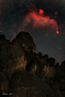 Seagull Nebula rising over rocks at Pinnacles National Park as seen with a telephoto lens -- Yes this is real its just too dim for you to see with the naked eye 