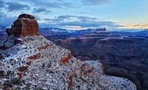 Snowy view of ONeil Butte in the foreground and Zoroaster Temple in the background at sunrise in the Grand Canyon Arizona 