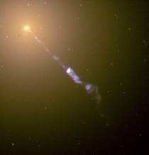 Streaming out from the center of the galaxy M like a cosmic searchlight is one of natures most amazing phenomena a black-hole-powered jet of electrons and other sub-atomic particles traveling at nearly the speed of light 